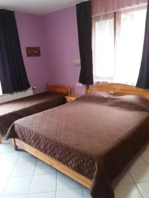 a bedroom with a bed and a window at Вила Сладък Живот in Tsigov Chark