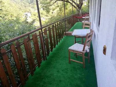 a balcony with a table and chairs on the grass at GUEST HOUSE ELENA in Kosovo