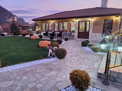 a backyard with a house with a lawn at Perla in Dospat