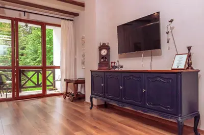 a living room with a black dresser with a television on it at 