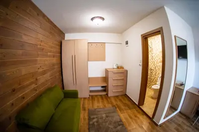 a living room with a green couch and a desk at Seven Springs Hotel in Banya