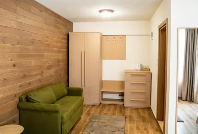 a living room with a green couch and a desk at Seven Springs Hotel in Banya