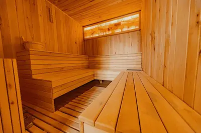 an empty wooden sauna with a window in it at Seven Springs Hotel in Banya