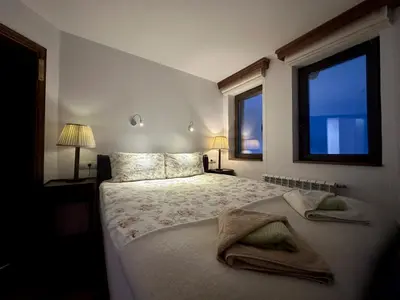 a bedroom with a bed with two pillows and a window at Stoykite-Pamporovo Nature Retreat in Stoykite