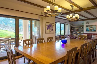 a dining room with a large wooden table and chairs at Stoykite-Pamporovo Nature Retreat in Stoykite