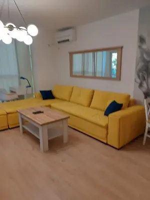 a living room with a yellow couch and a coffee table at Sandanski Apartments Top Center in Sandanski