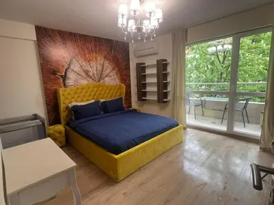 a bedroom with a large yellow bed and a balcony at Sandanski Apartments Top Center in Sandanski