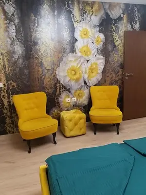two yellow chairs in a room with flowers on the wall at Sandanski Apartments Top Center in Sandanski