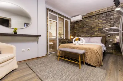 a bedroom with a bed and a brick wall at 1BD Apartment - 5 mins to the city centre by Flat Mаnager in Plovdiv