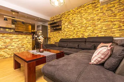 a living room with a couch and a brick wall at 1BD Apartment - 5 mins to the city centre by Flat Mаnager in Plovdiv