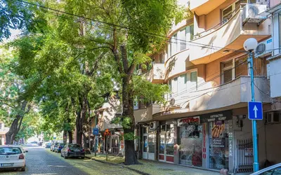 a city street with a building and a tree at 1BD Apartment - 5 mins to the city centre by Flat Mаnager in Plovdiv