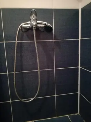 a shower head on a tiled wall in a bathroom at Вила Хоризонт in Tsigov Chark