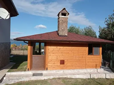 a large wooden garage with a brick chimney on top at Вила Хоризонт in Tsigov Chark