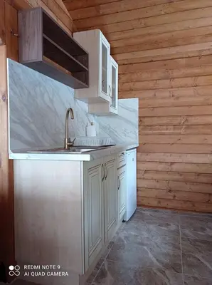 a kitchen with white cabinets and a sink at Вила Хоризонт in Tsigov Chark