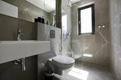 a bathroom with a white toilet and a sink at Connect Living Apartments in Sofia