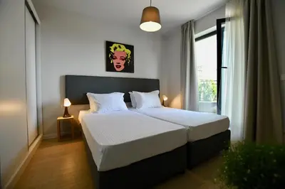 a bedroom with a large bed with white sheets at Connect Living Apartments in Sofia