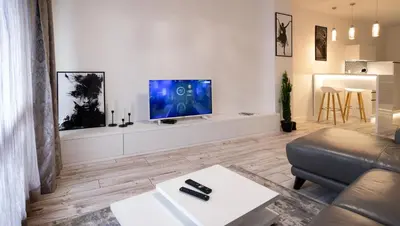 a living room with a couch and a tv on a wall at Beautiful Place in The Heart of The City!!!! in Plovdiv