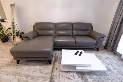 a living room with a leather couch and a table at Beautiful Place in The Heart of The City!!!! in Plovdiv