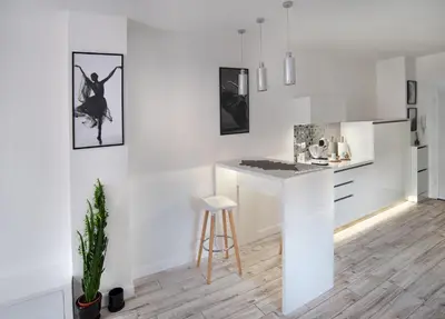 a white kitchen with a counter and a stool at Beautiful Place in The Heart of The City!!!! in Plovdiv