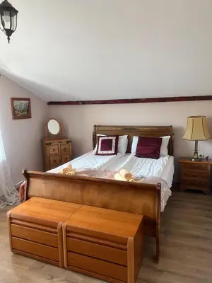 a bedroom with a large bed with a wooden frame at Guest House Kalina in Sapareva Banya