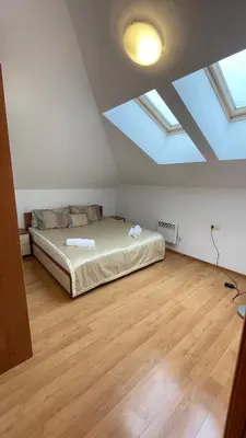 a bedroom with a bed in a room with skylights at Two bedroom flat in Magernitsa in Bansko