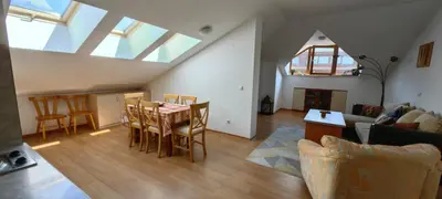 a living room with a table and chairs and a couch at Two bedroom flat in Magernitsa in Bansko