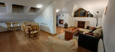 a living room with a couch and a table at Two bedroom flat in Magernitsa in Bansko