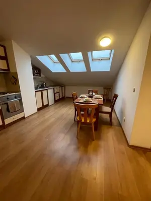 a living room with a table and chairs and skylights at Two bedroom flat in Magernitsa in Bansko