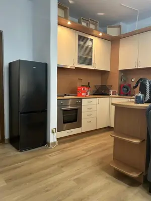 a kitchen with a black refrigerator and white cabinets at Sandanski Apartments Park Center in Sandanski