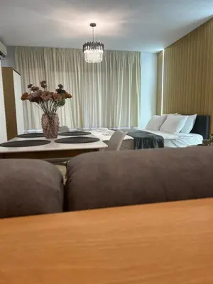 a hotel room with a bed and a table with flowers at Sandanski Apartments Park Center in Sandanski