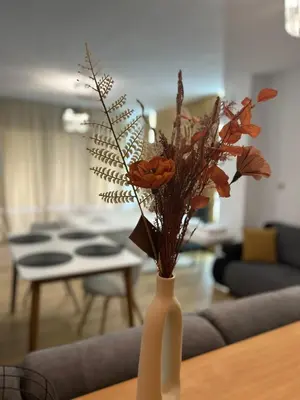 a white vase filled with flowers on a table at Sandanski Apartments Park Center in Sandanski