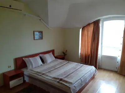 a bedroom with a large bed and a large window at Хотелски Комплекс Авалон in Asenovgrad
