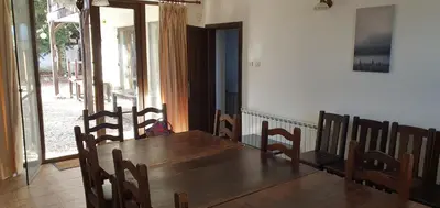 a dining room with a wooden table and chairs at Guest House Ela in Dolna Banya