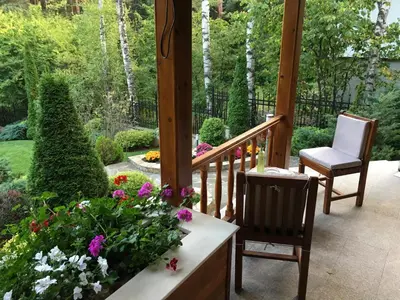 a porch with two chairs and flowers at Luxury Villa Borina in Zheleznitsa