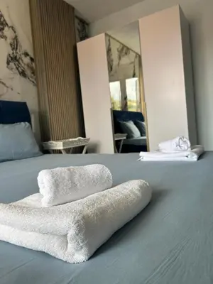 a pile of towels sitting on top of a bed at Didi Park House къща с две спални in Sandanski