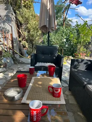 a patio with a table with red cups and an umbrella at Didi Park House къща с две спални in Sandanski