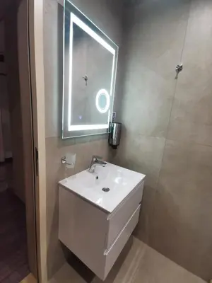 a bathroom with a white sink and a window at Paradise Swing Apartment Sofia in Sofia