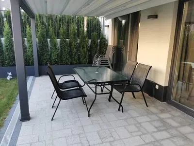 a glass table and chairs on a patio at Paradise Swing Apartment Sofia in Sofia