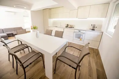 a kitchen and dining room with a white table and chairs at Villa Detelina in Sapareva Banya