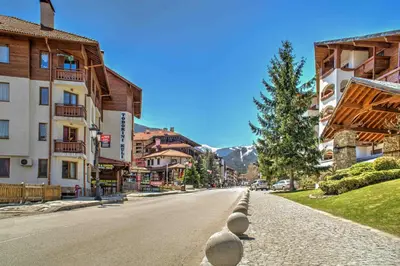 a street in a town with buildings and a tree at Bansko Studio 30m From Gondola - T.K. 4B in Bansko