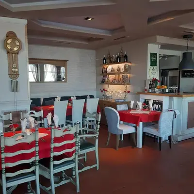 a dining room with tables and chairs and a clock at Gondola 1 BDRM Flat in Cedar Lodge IV (D2) in Bansko