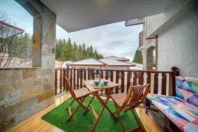 a balcony with a table and two chairs on a porch at MyPlace Pamporovo апартаменти за отдих in Pamporovo