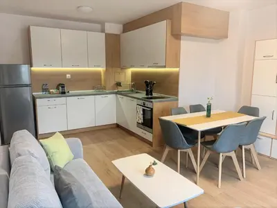 a kitchen and living room with a couch and a table at Gardenia Apartments in Sofia