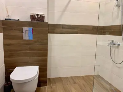 a bathroom with a toilet and a glass shower at Gardenia Apartments in Sofia