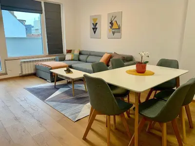 a living room with a table and a couch at Gardenia Apartments in Sofia