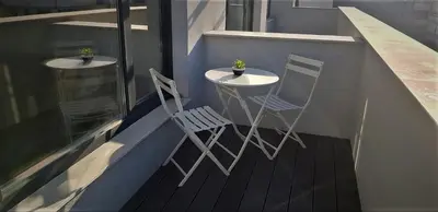 two chairs and a table on a balcony at Gardenia Apartments in Sofia