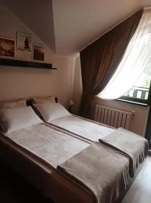 a bedroom with a large bed with a window at Апартамент С-59 в Апарт-хотел Боровец Гардънс in Borovets