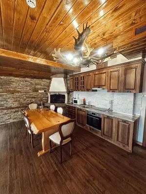 a kitchen with a wooden table and a wooden ceiling at Къщи за гости 