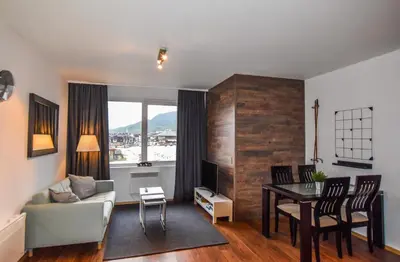 a living room with a couch and a table at Bansko Royal Towers Apartments - Gondola View in Bansko