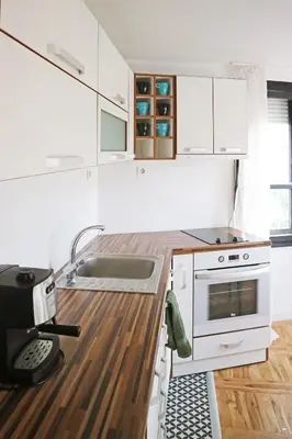 a white kitchen with a sink and a stove at Modern Cozy Apartment in Kyustendil